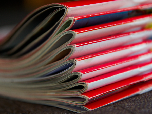 Ein Zeitschriftenstapel mit roten Zeitschriften, die übereinander liegen.